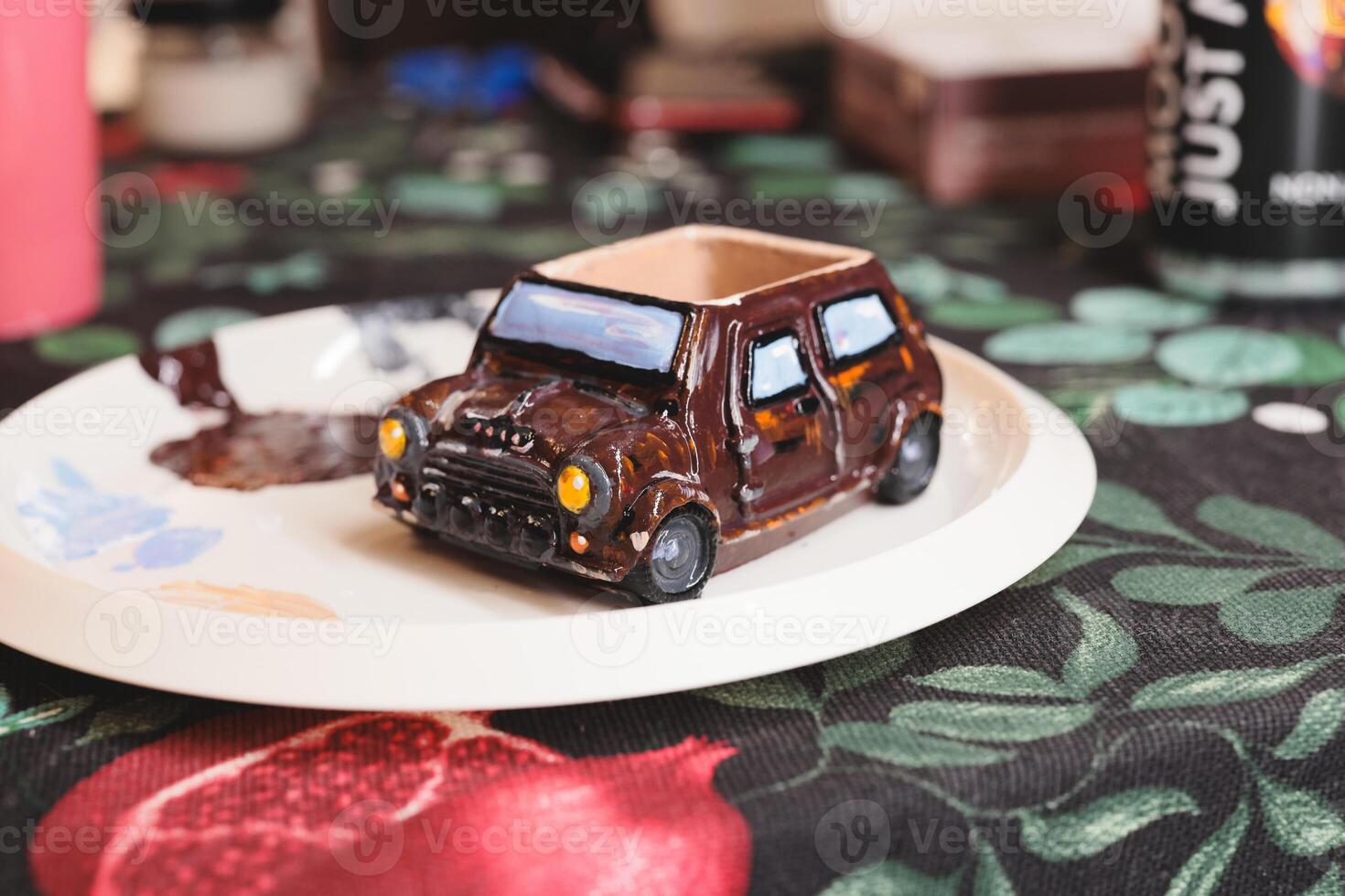 This is a unique handpainted miniature car sculpture that sits beautifully on a decorative plate photo