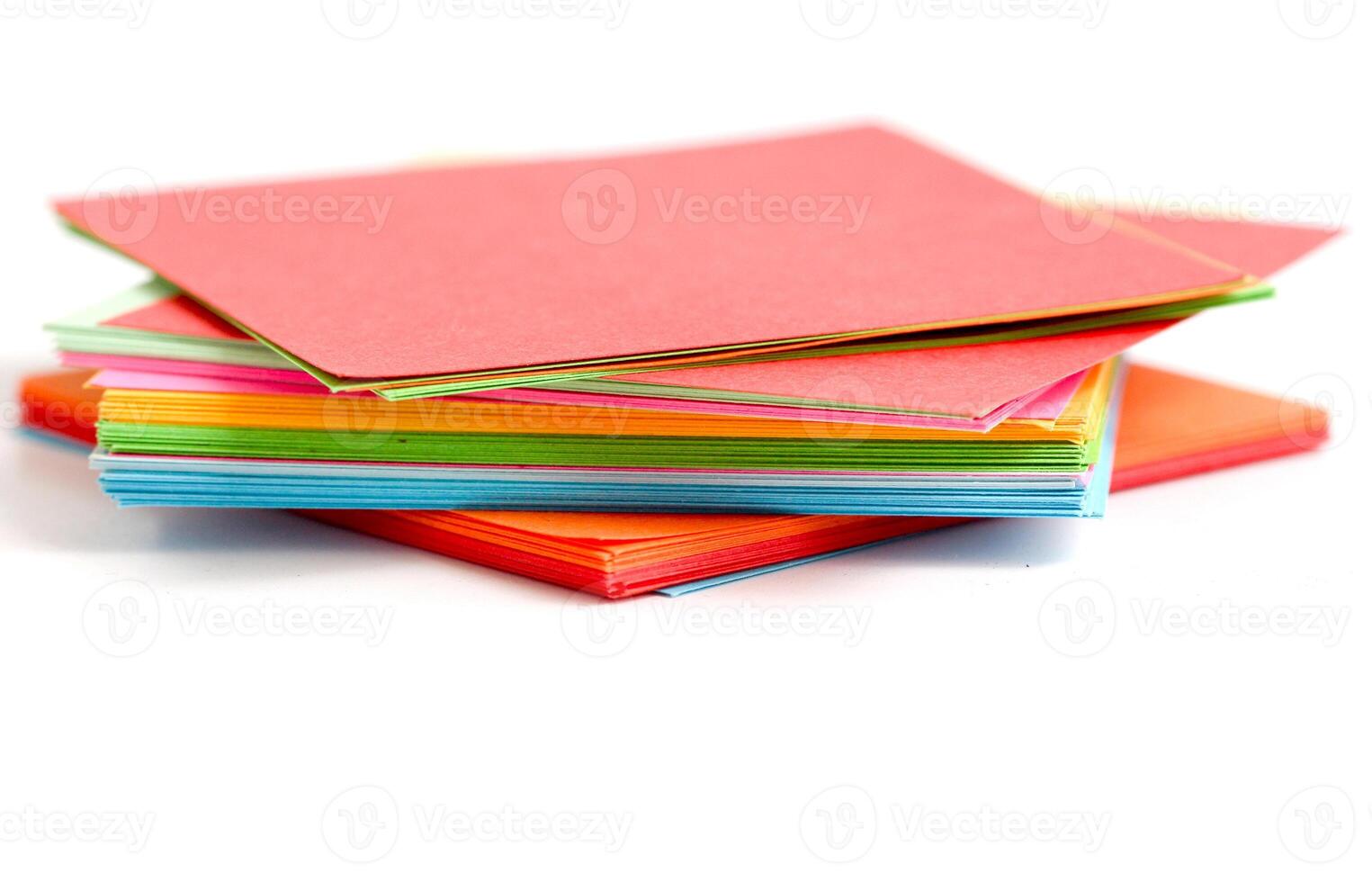 A stack of colorful paper on a white background photo