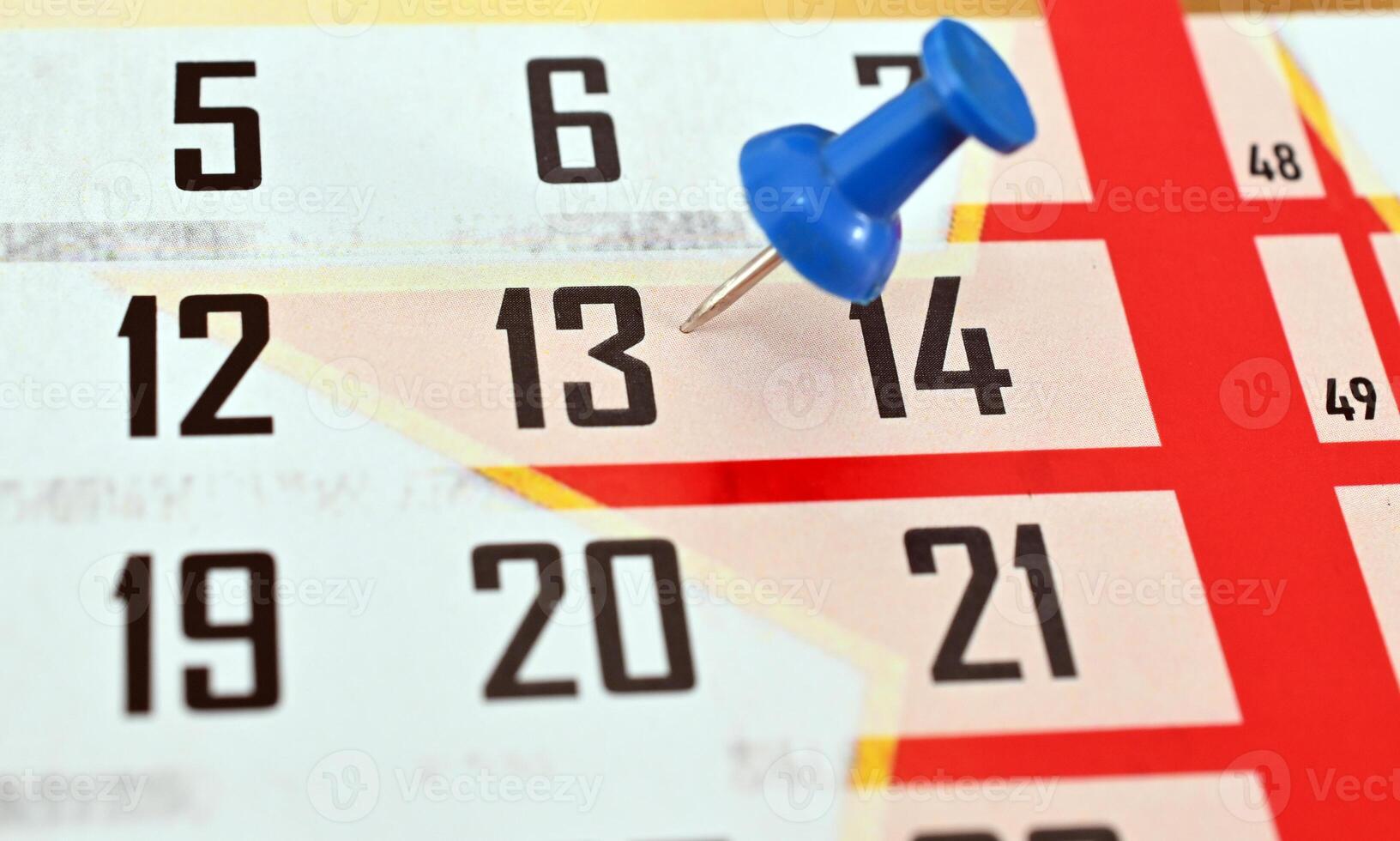 A calendar with a blue push pin on the top photo