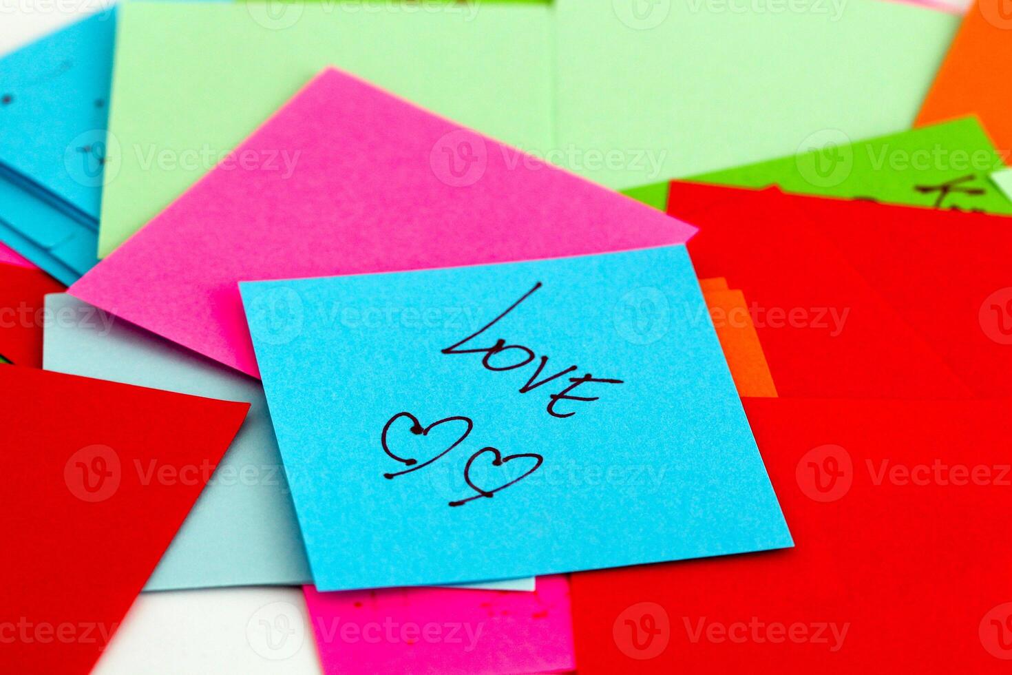 A pile of colorful post-it notes with the word love written on them photo