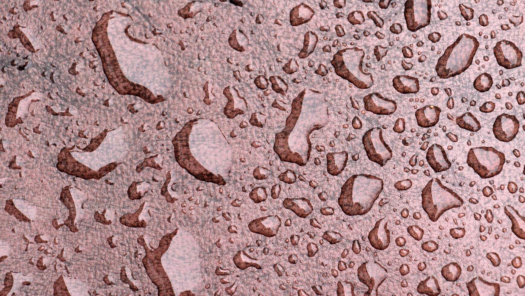 Water drops on a surface with brown and pink colors photo