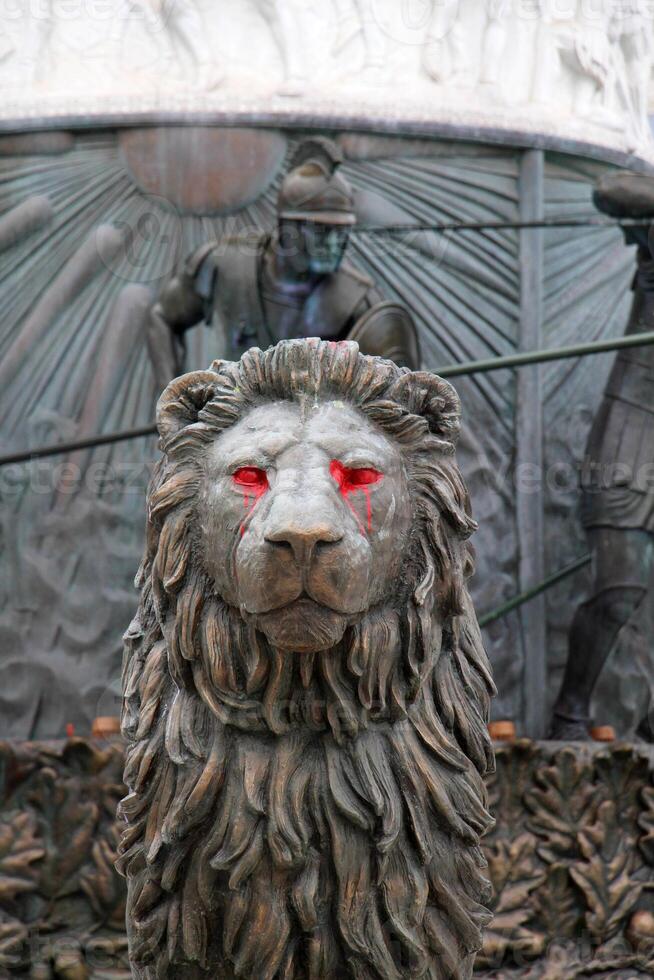 Lion statue. with red paint on eyes photo
