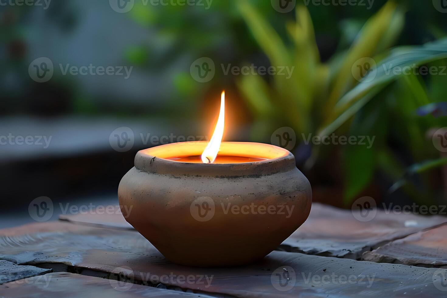 A Glowing Candle Flame Illuminates a Rustic Clay Pot at Dusk, Creating a Serene and Tranquil Atmosphere. Symbol of Peace and Reflection in Nature's Embrace. photo