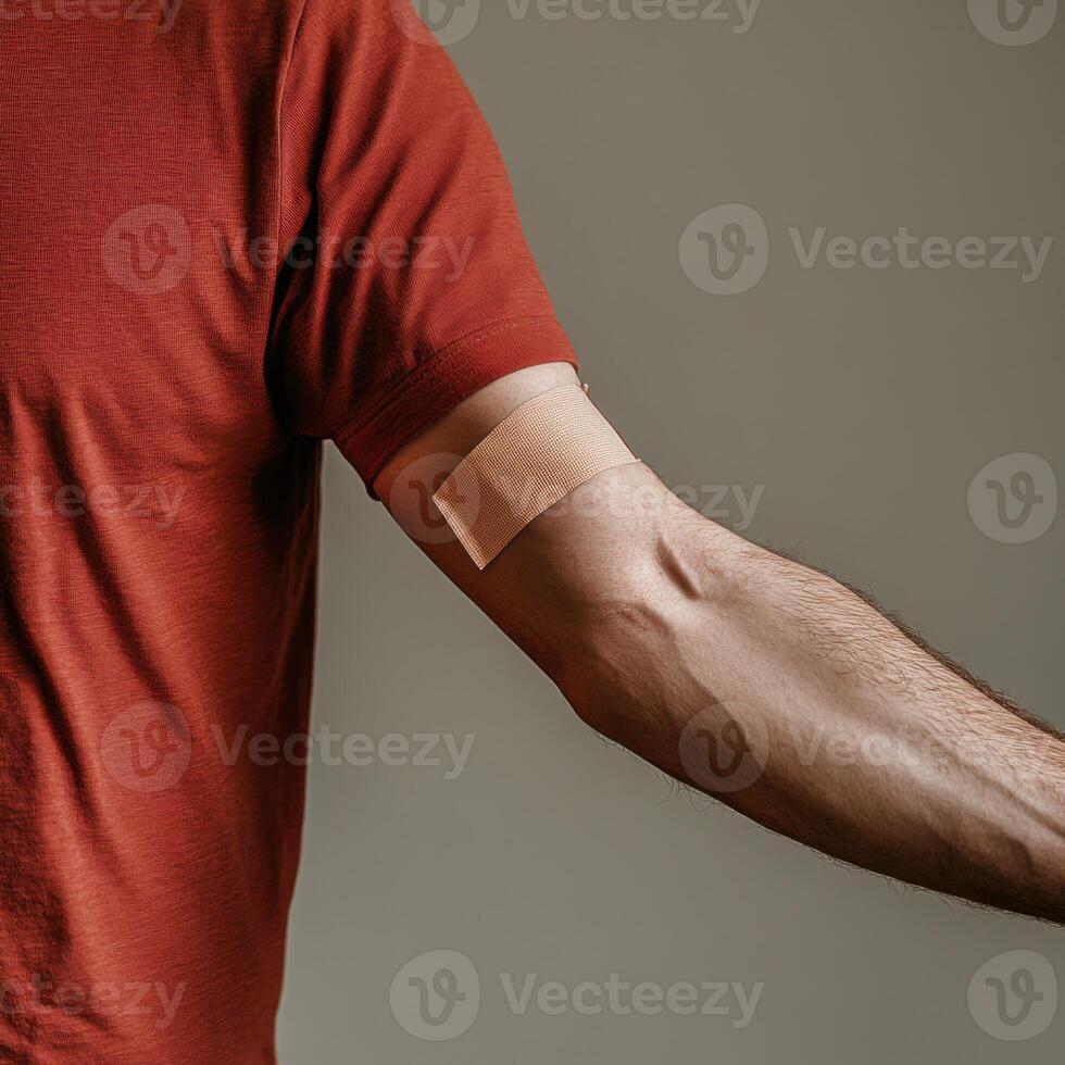 Bandage on arm after receiving vaccination in a healthcare setting during daylight photo