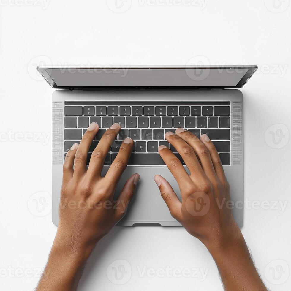 Hands typing on a laptop keyboard on a white surface in a bright workspace photo