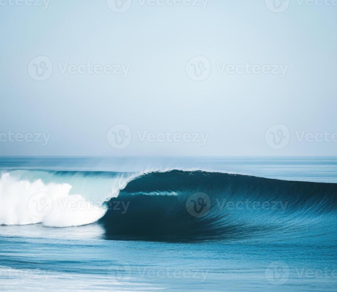 Surfing wave breaks along a calm shore under clear skies during early morning light photo
