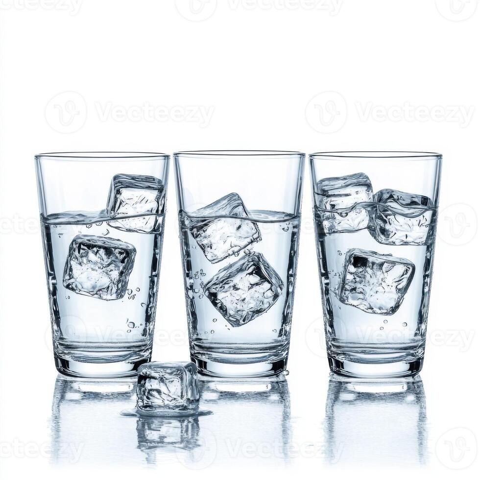 Refreshing cold water with ice cubes served in three glasses on a white background photo