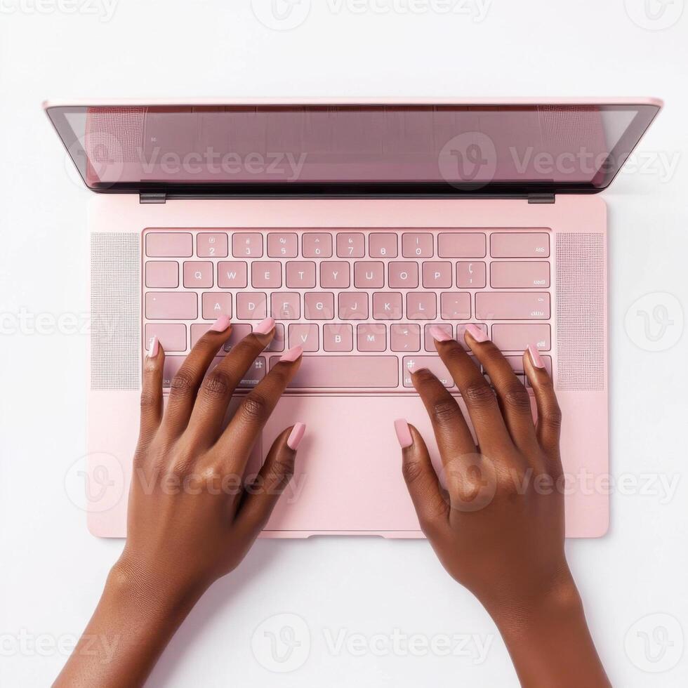Person typing on a pink laptop with a clean workspace setup during daylight in a contemporary indoor environment photo
