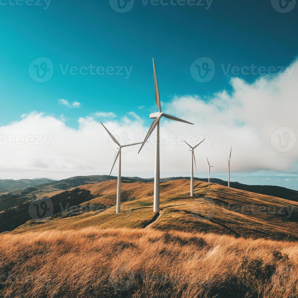 Wind turbines stand tall on rolling hills under a clear blue sky in a remote area of nature during daylight hours photo