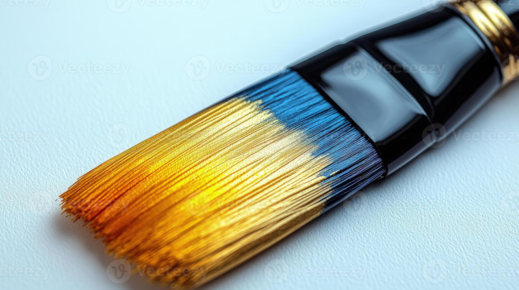 A close-up of a paintbrush with stunning golden and blue bristles for creative work photo