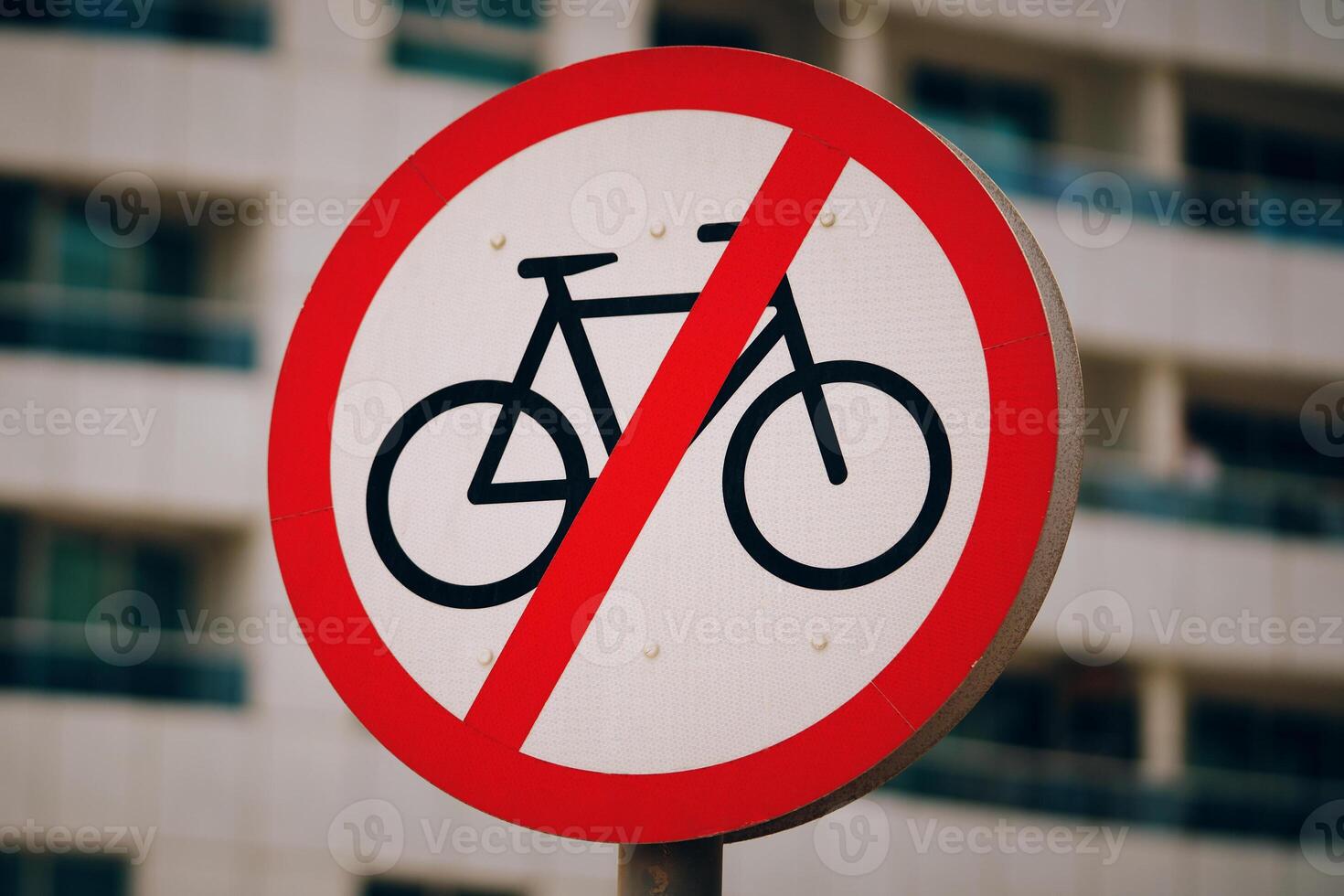 A red and white traffic sign with bold font that prohibits bicycles from entering. The sign specifically states No bicycles allowed to prevent any twowheeled vehicles from using the road photo