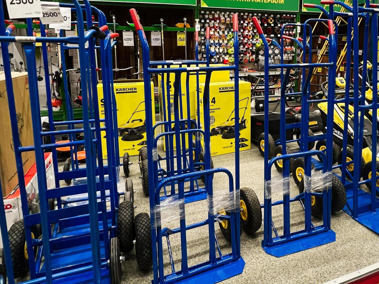 Kyiv, Ukraine - January 03, 2025 Blue hand trucks aligned for sale in a hardware store photo