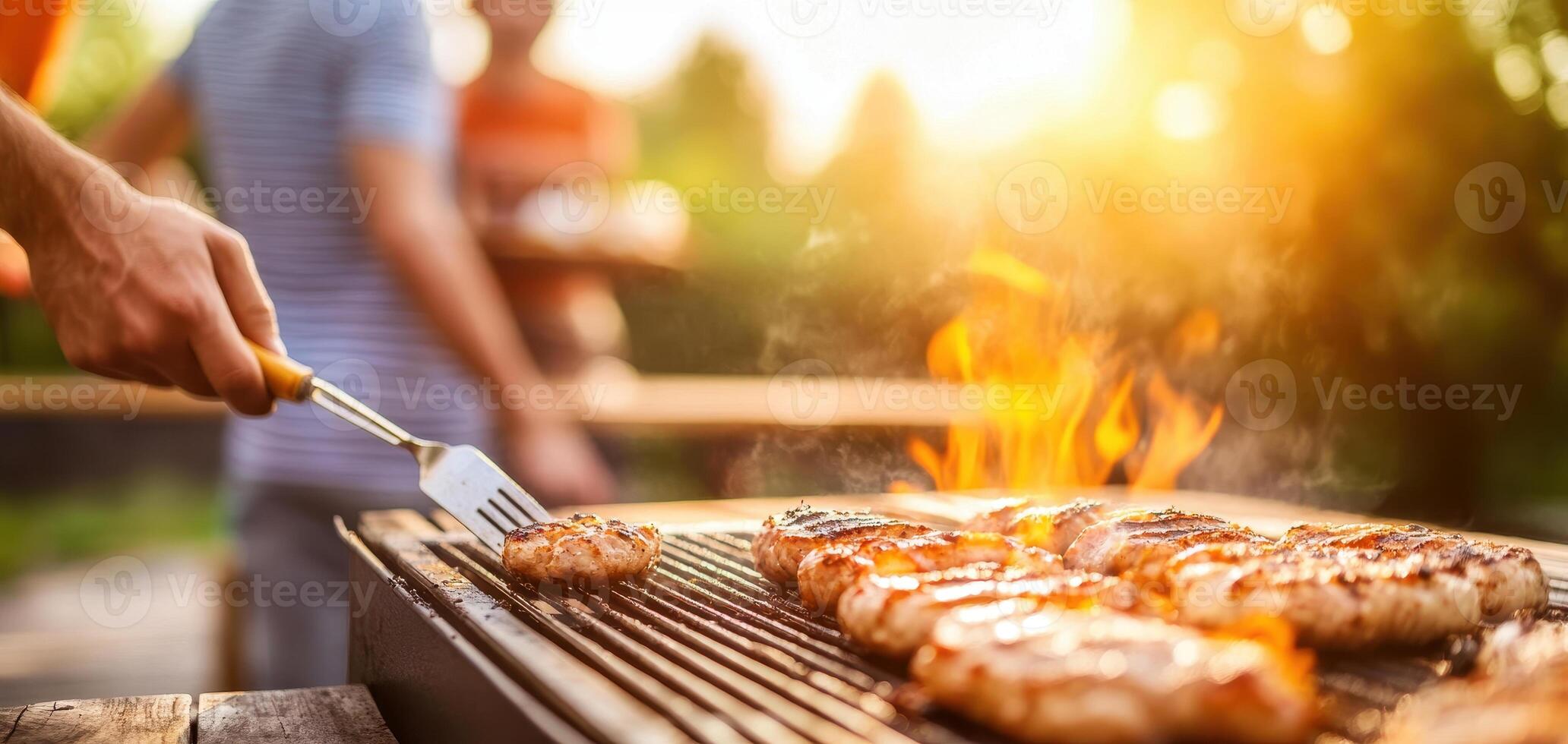 family enjoying outdoor barbecue with grilled meat and flames photo