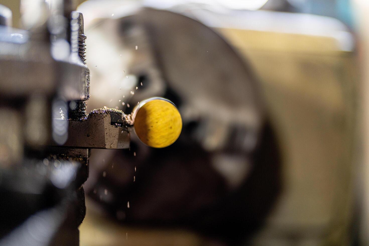 A close up of a machine operating a metal lathe shows a steel column rolling inside the equipment, highlighting processes in the metalworking industry. photo