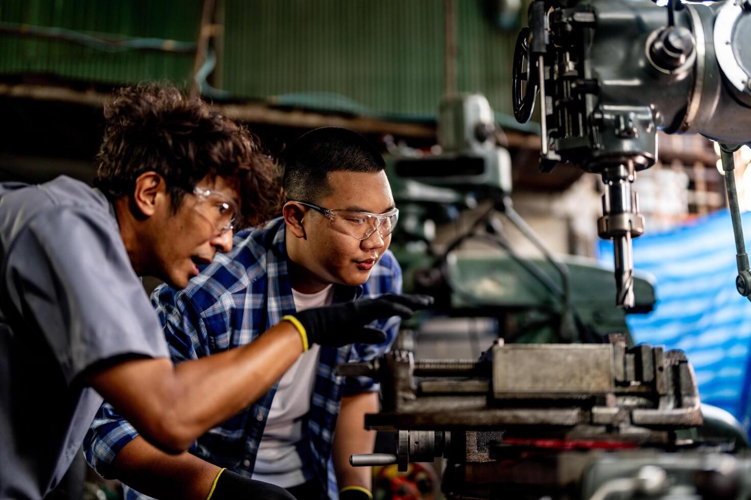 A professional worker uses a drilling machine to complete tasks in a busy factory environment. photo