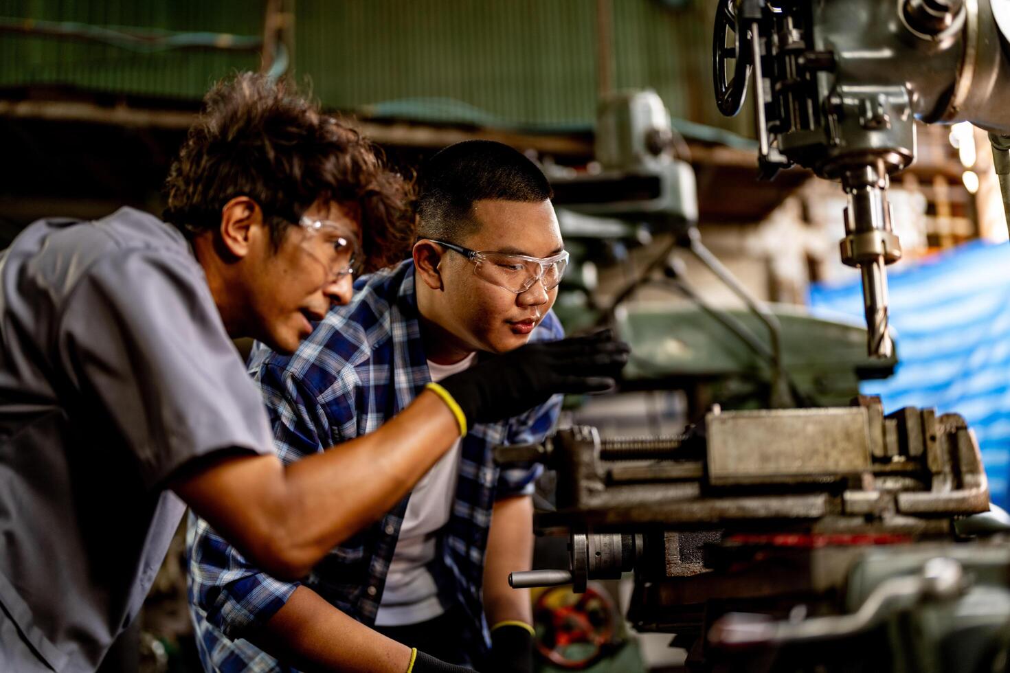 In a production plant, an Asian worker operates machinery with careful attention to detail. photo