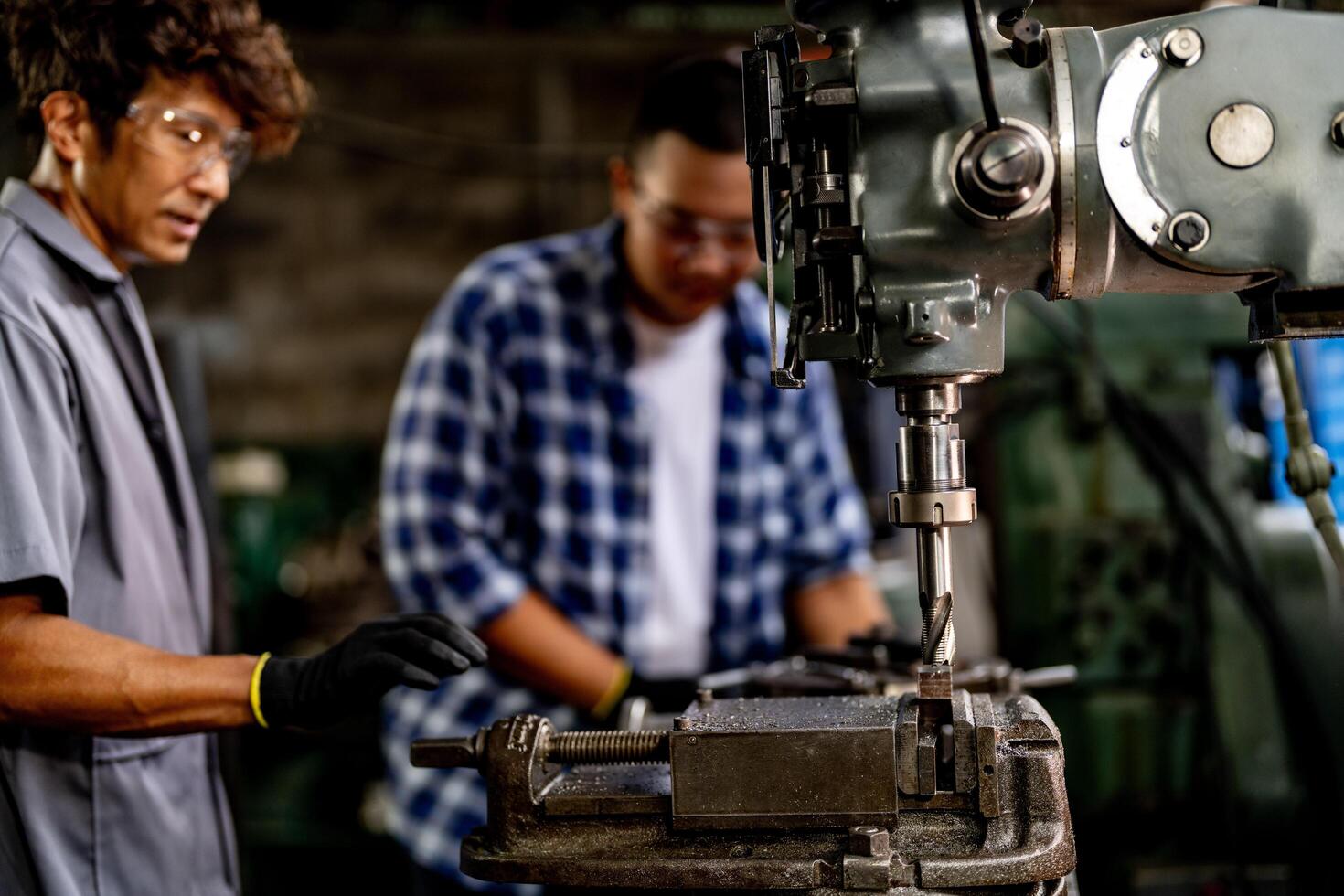 A skilled worker drills into metal at a production facility, demonstrating expertise. photo