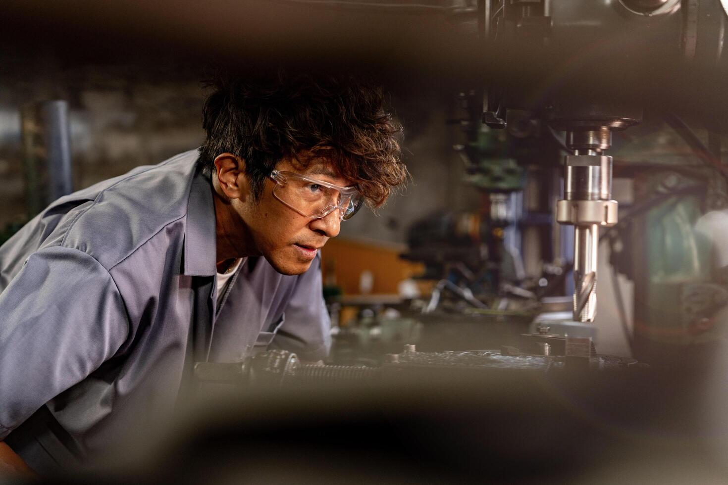 A skilled operator works with precision to drill into metal at a busy production facility. photo