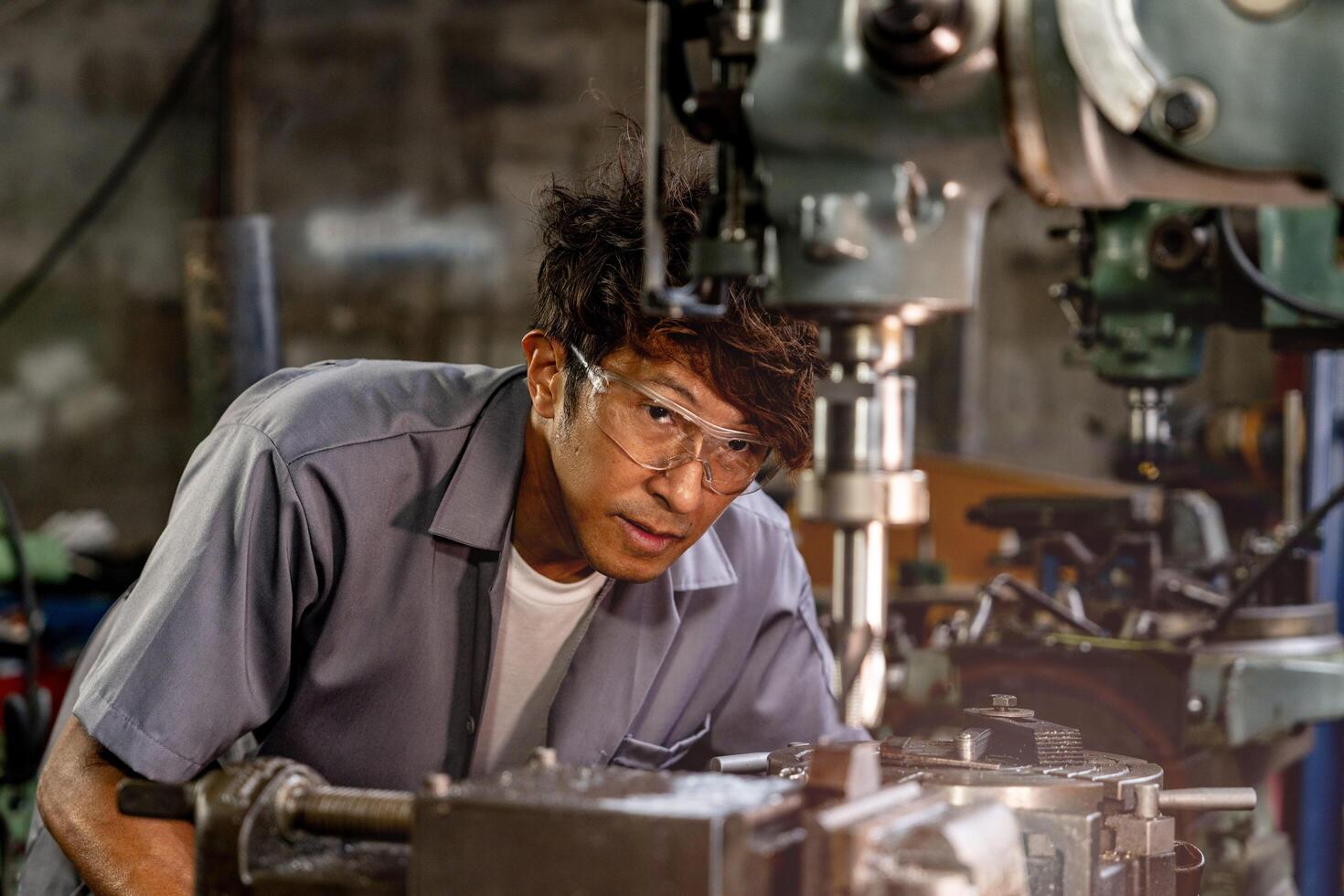 A worker in a production plant uses a lathe grinder to finish the interior surface of steel. photo