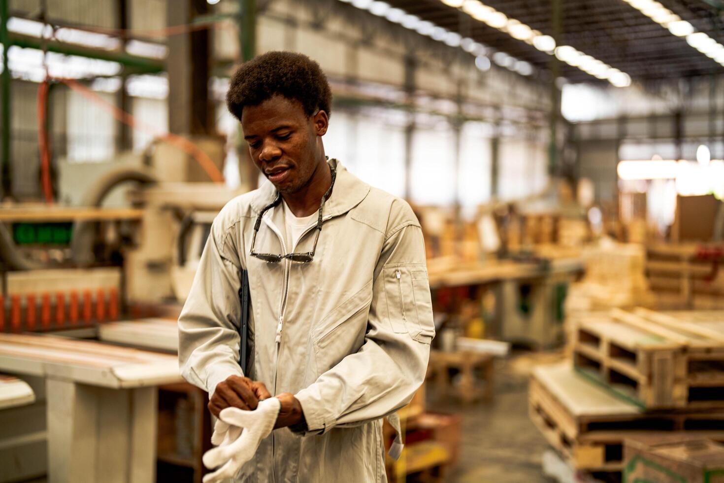 African man workers engineering standing with confidence with working suite dress and hand glove in front machine. photo