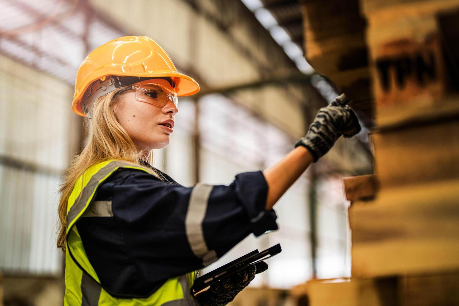 A female carpenter carefully checks the quality of wooden pieces in the manufacturing workshop. photo