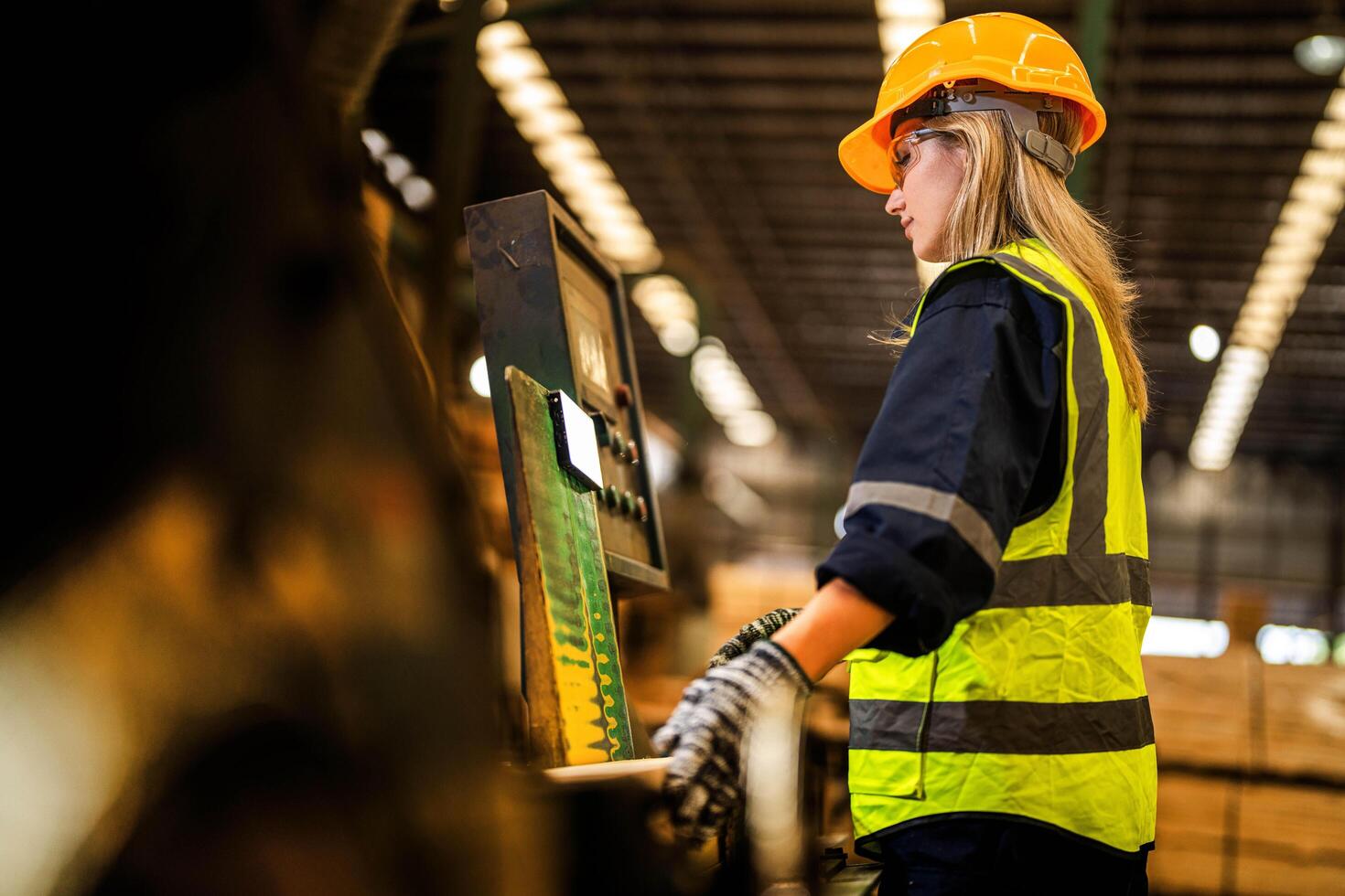 Factory engineer woman standing confident to control panel. Worker works at heavy machine at industry factory. worker checking timber of raw wood material. photo