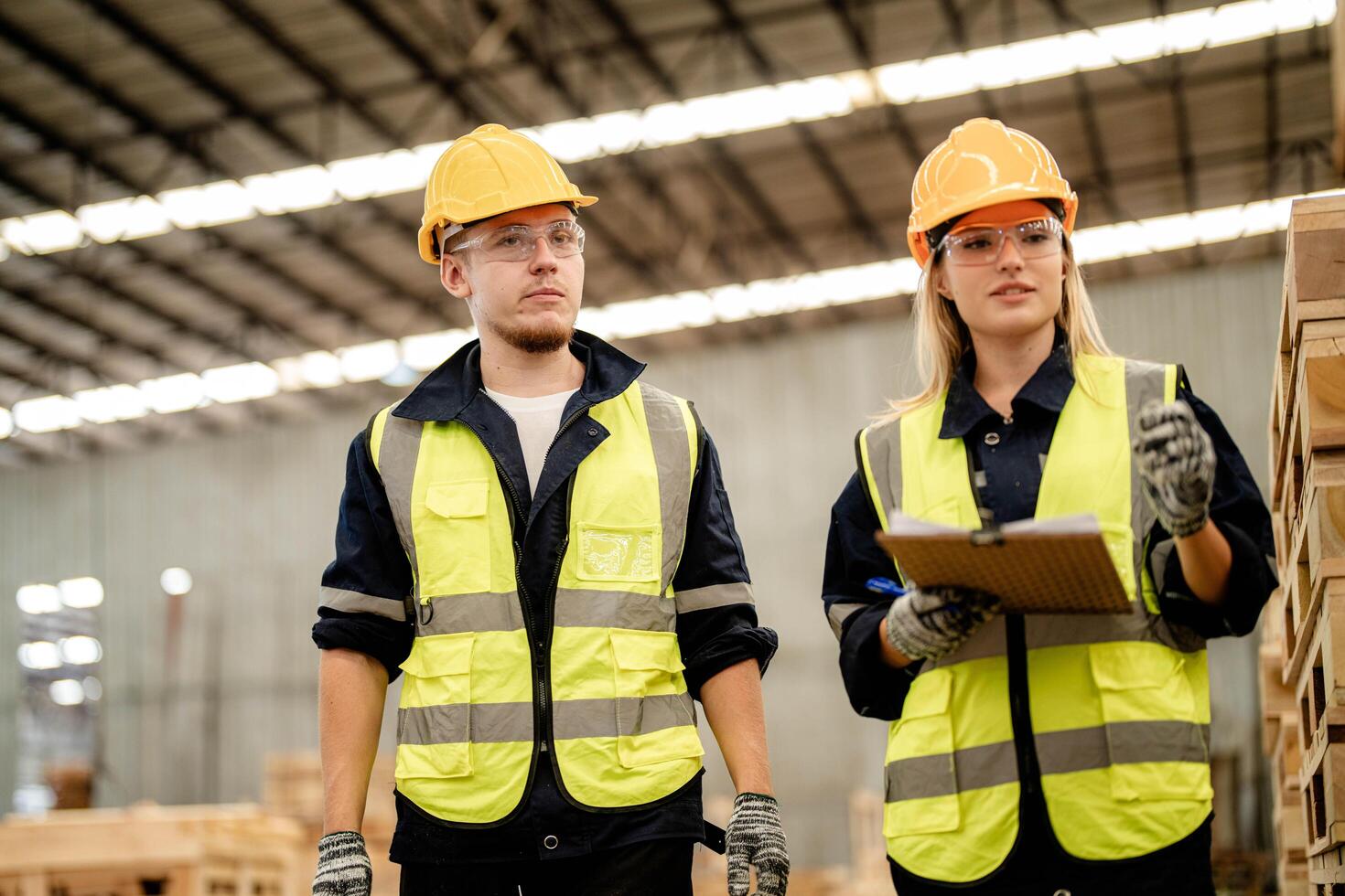 Engineers walk through the warehouse, inspecting timber wood for quality control. photo