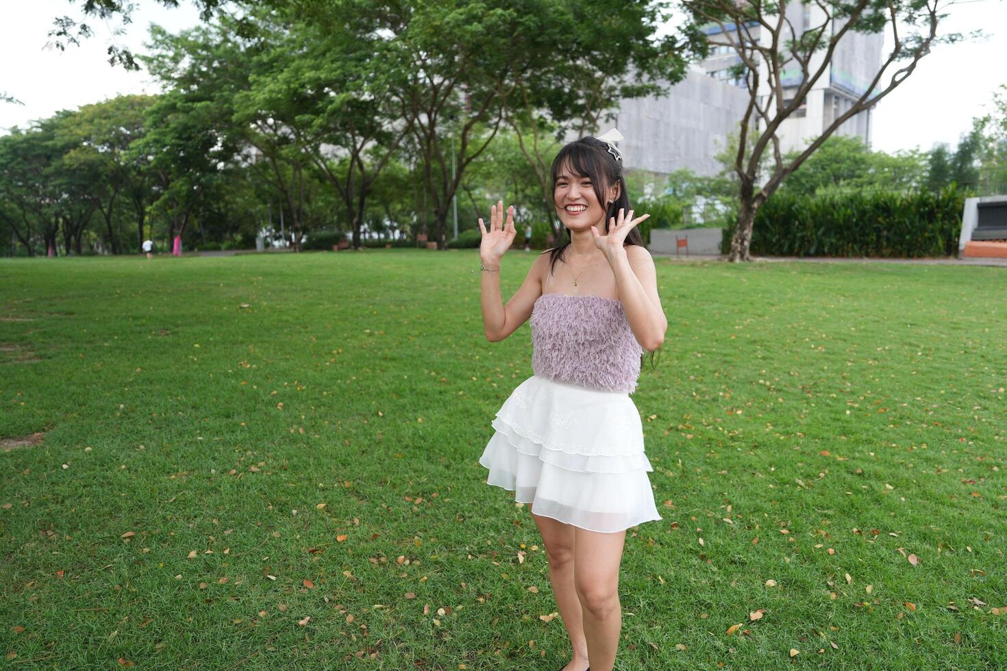 A woman dances happily in doors, set against a decorative brick wall and lush plants, symbolizing freedom and energy. photo