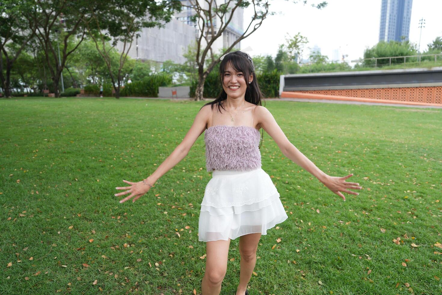 A woman dances happily indoors, se t against beautiful greenery and a scenic view, symbolizing harmony and peace. photo