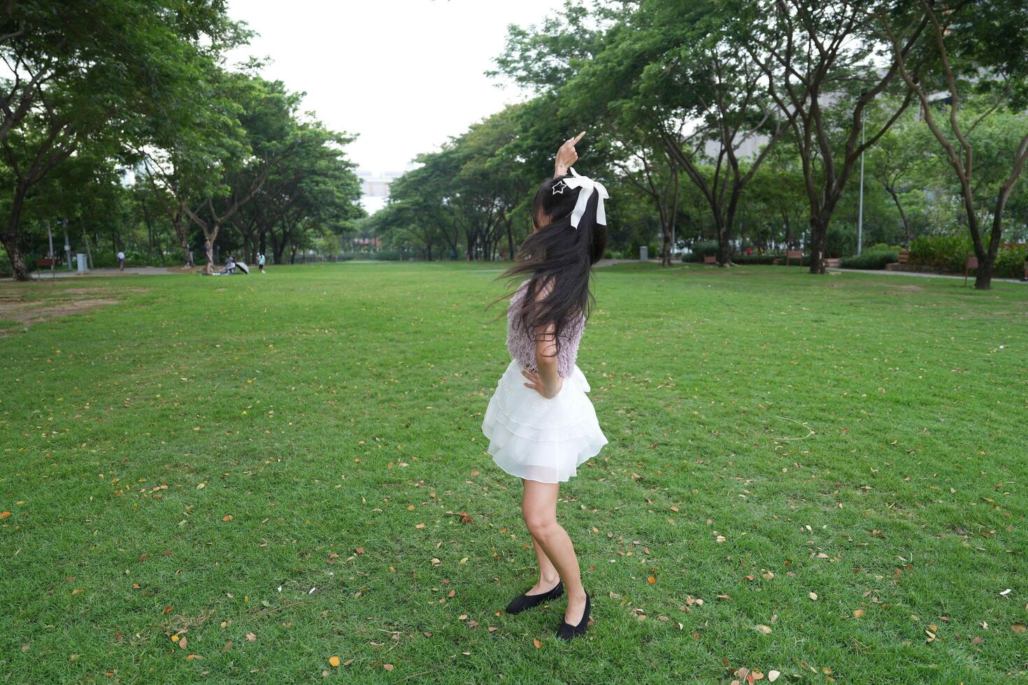 A joyful young woman dances in harmony indoors, with b eautiful greenery and lush plants enhancing the harmony and peace. photo