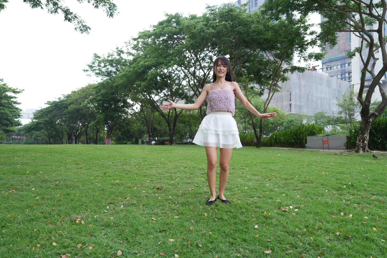 A serene ind oor space with beautiful greenery and lush plants surrounds a dancing woman, capturing pure joy. photo