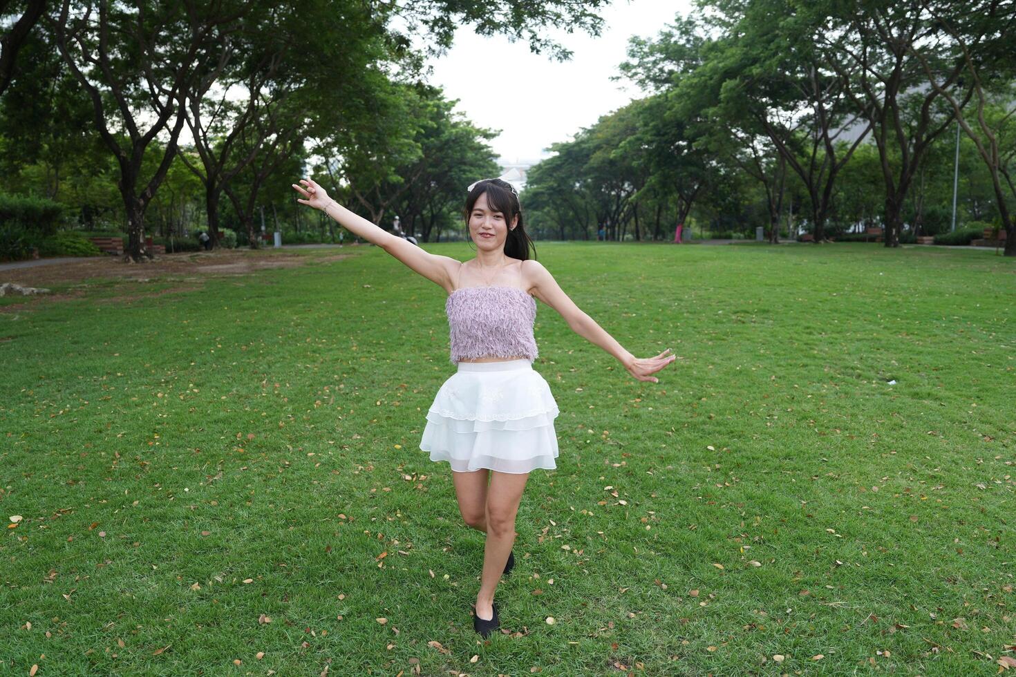 A woman dances happily indoors, set agai nst large windows and lush plants, symbolizing harmony and peace. photo