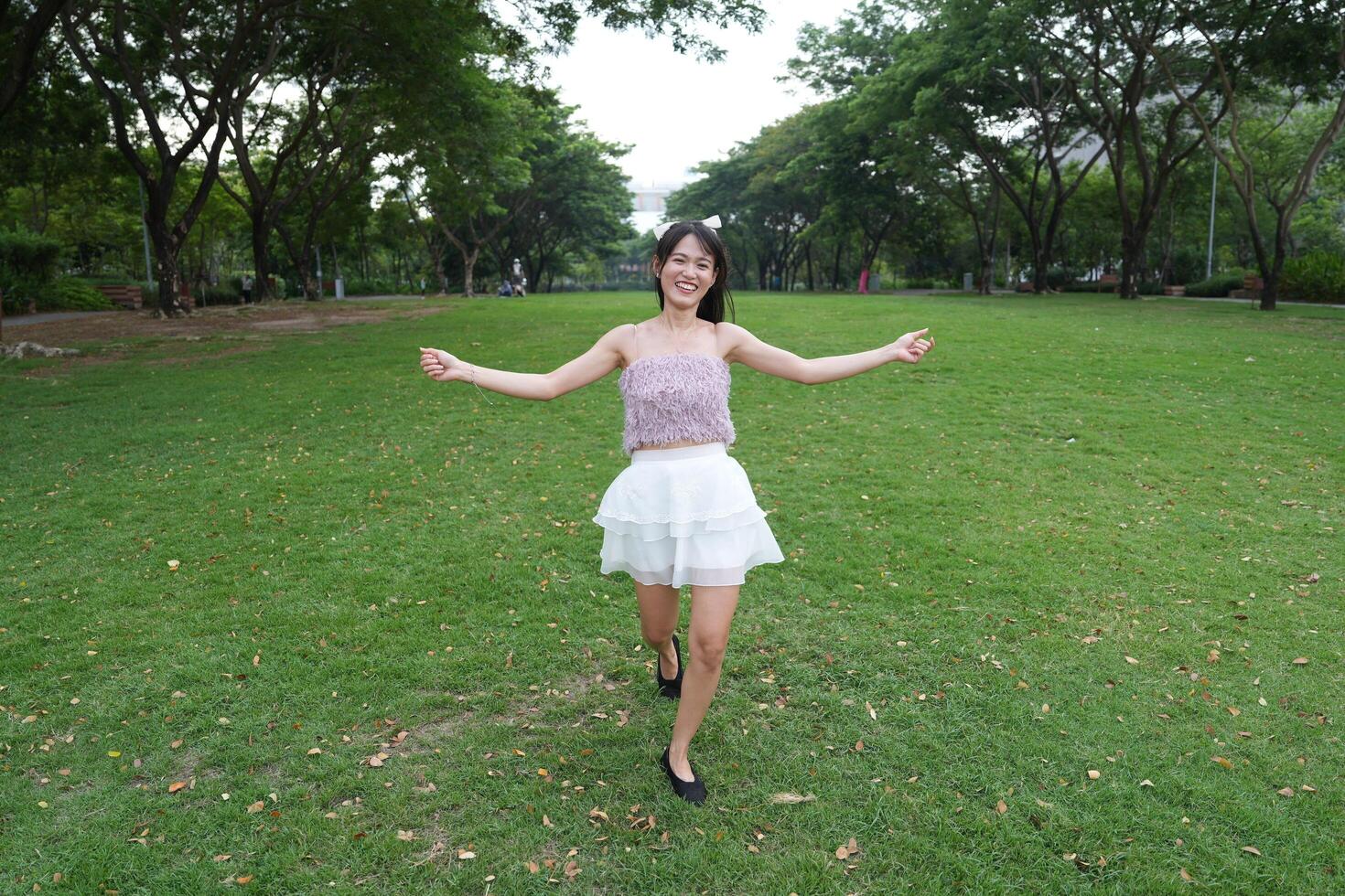 In a calm i ndoor area, a woman dances freely near large windows and lush plants, radiating harmony and peace. photo