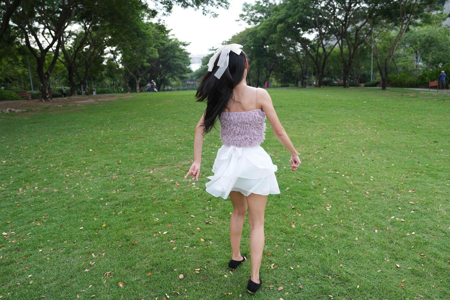 A joyful you ng woman dances in harmony indoors, with beautiful greenery and lush plants enhancing the harmony and peace. photo
