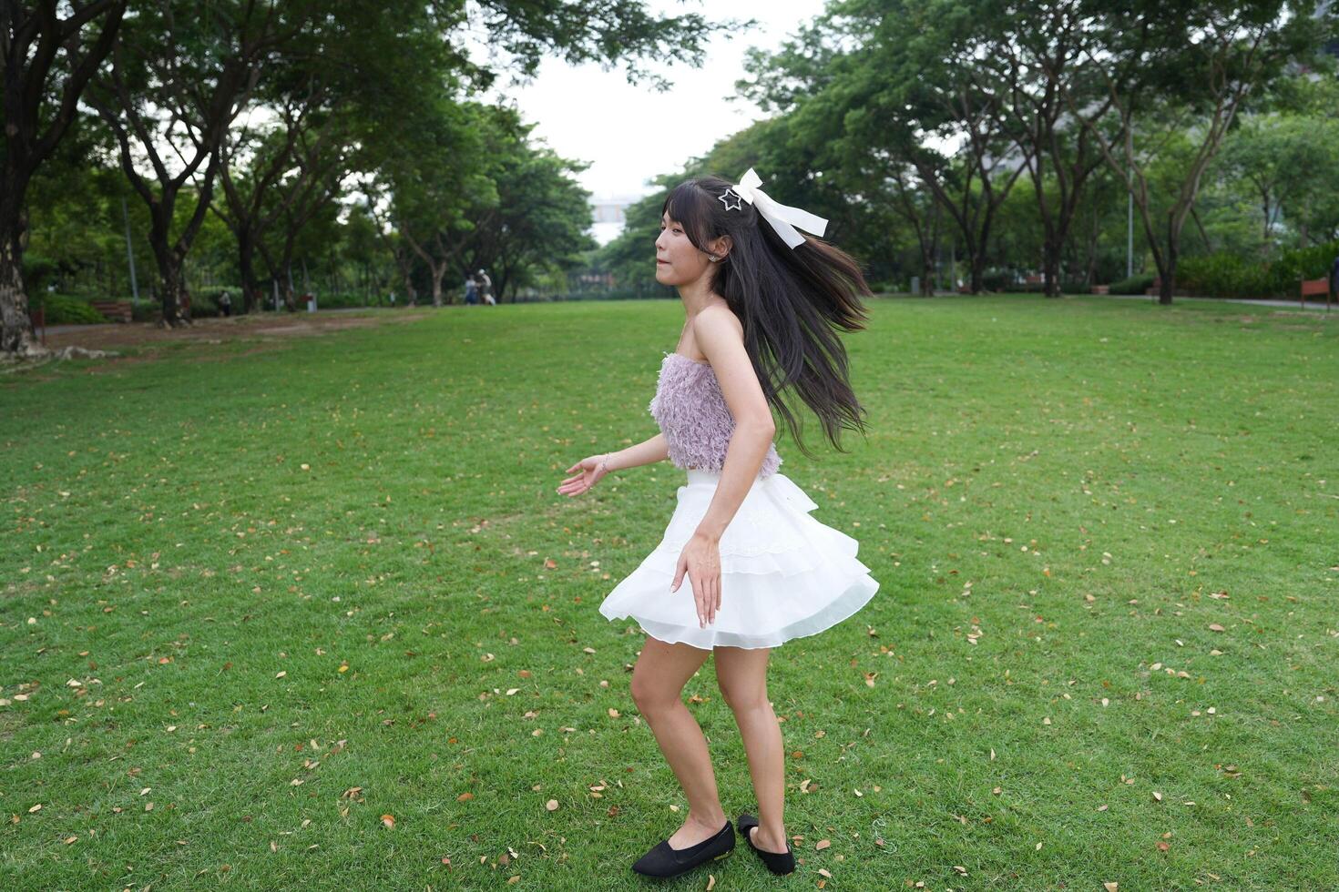 A joyful you ng woman dances in harmony indoors, with large windows and a scenic view enhancing the harmony and peace. photo