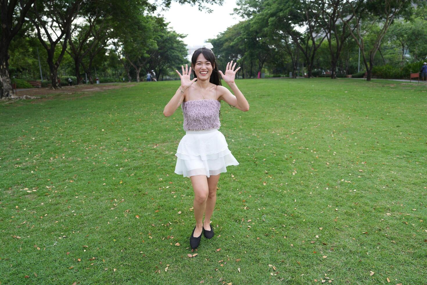 A woman dances hap pily indoors, set against beautiful greenery and lush plants, symbolizing freedom and energy. photo