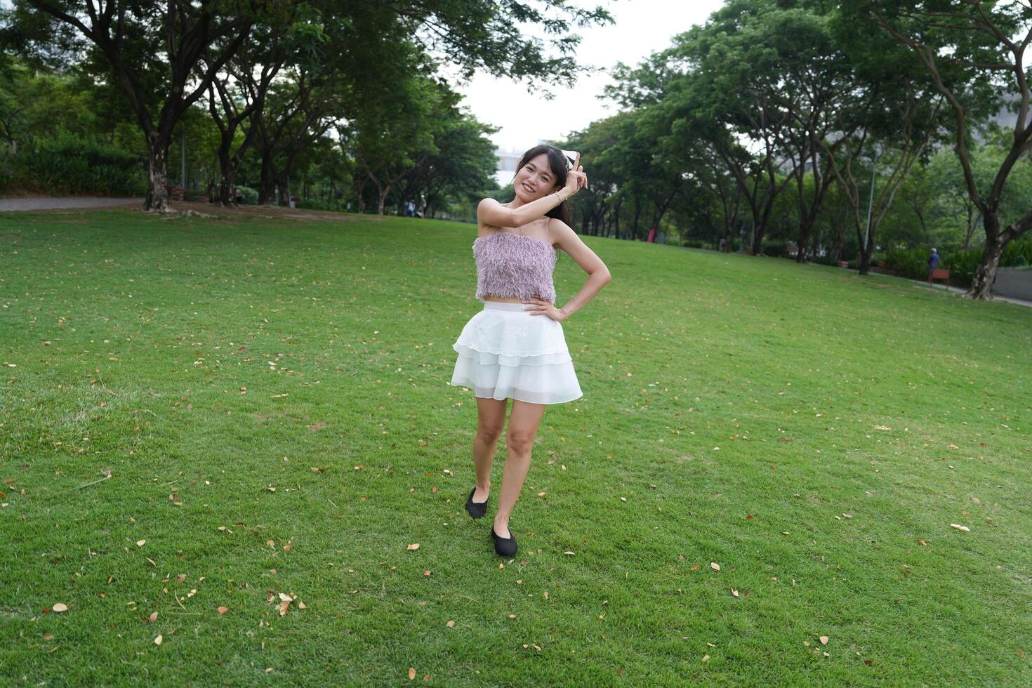 A joyful young woman dances i n harmony indoors, with large windows and natural light enhancing the pure joy. photo