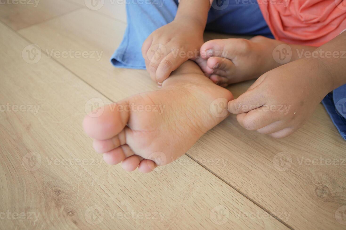 a kid suffering from itching skin on feet photo