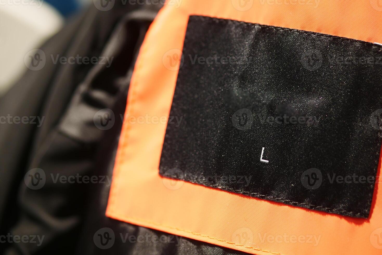 Close-Up View of a Black Label on an Orange Fabric Surface photo