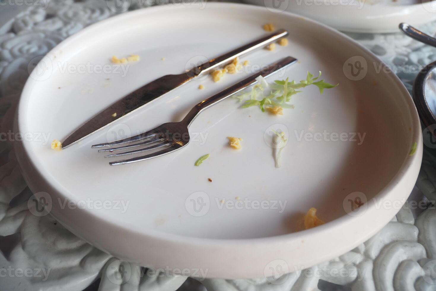 An empty dirty plate with a fork. photo