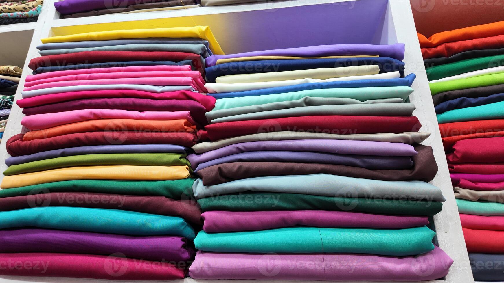 A Vibrant and Colorful Stack of Various Fabric Rolls in a Craft Store photo