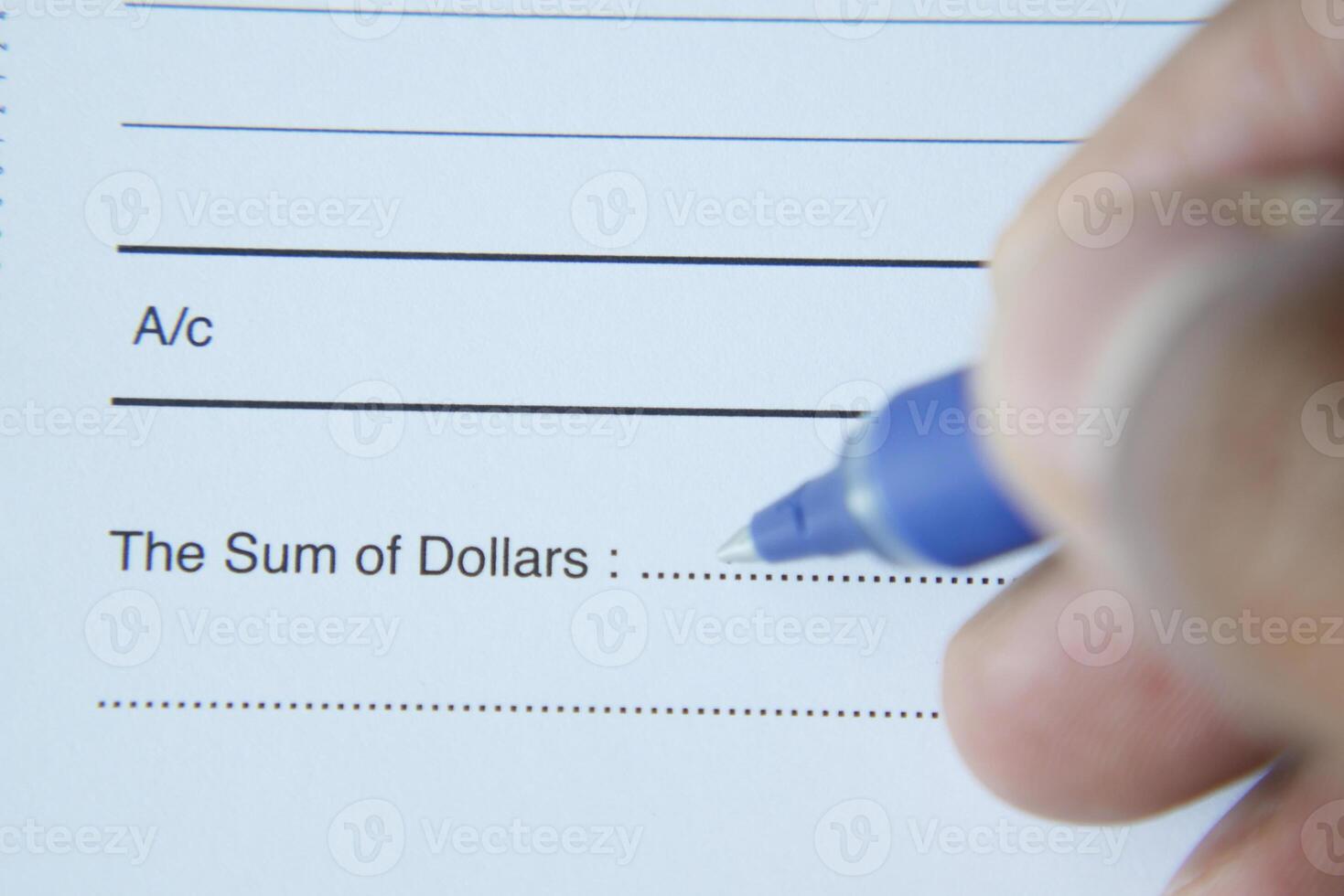 A person using a blue pen for handwriting on a financial document photo