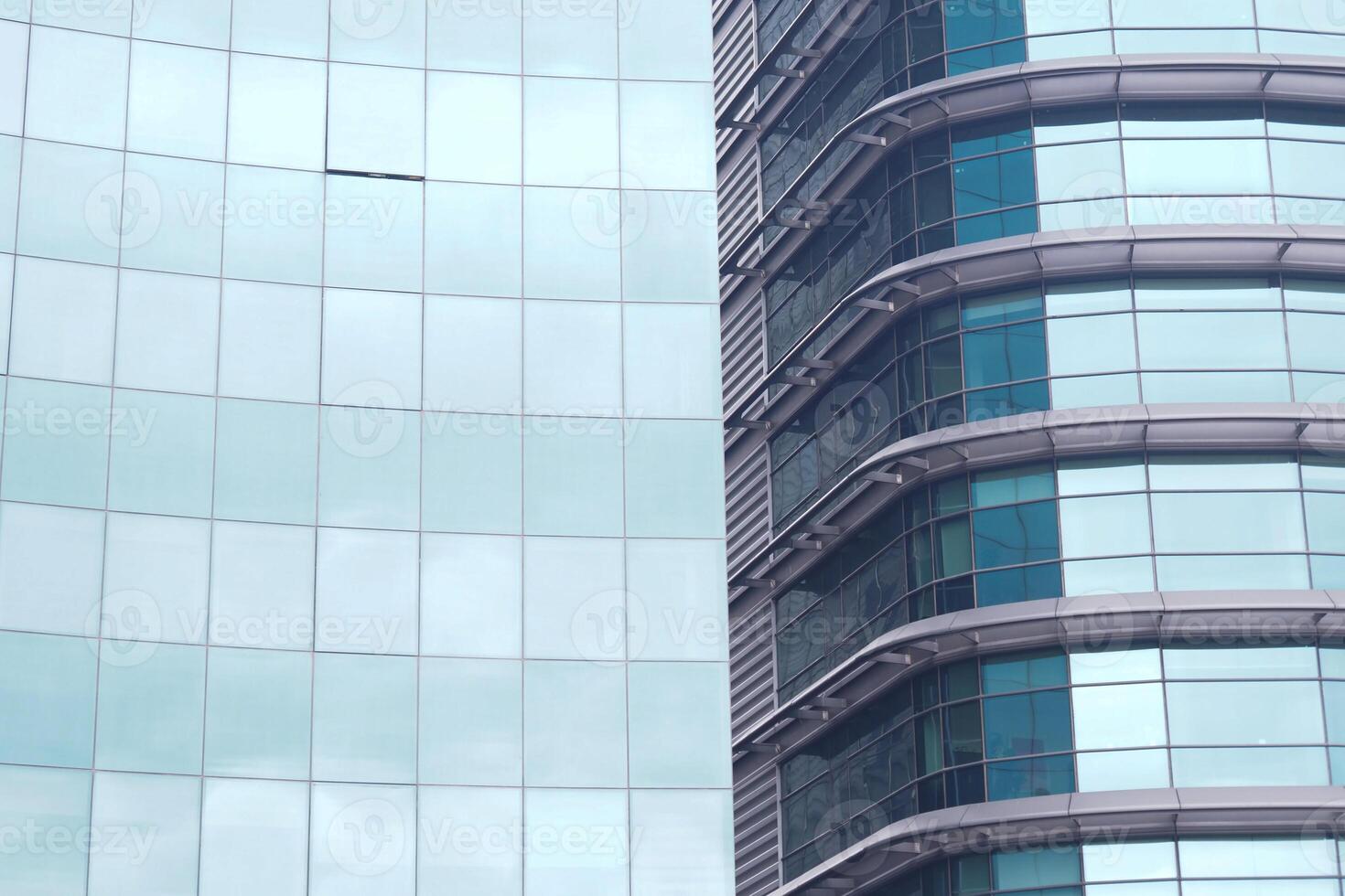A modern office building facade with large glass windows that reflect its surroundings photo