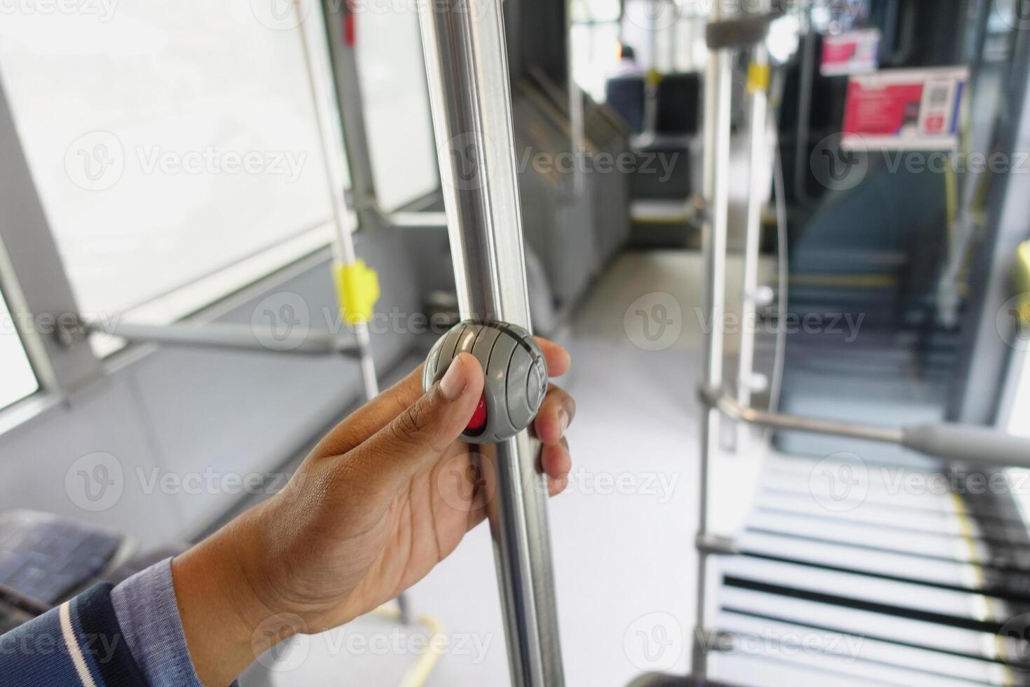 A passengers perspective while holding a metal pole on a city bus during the ride photo
