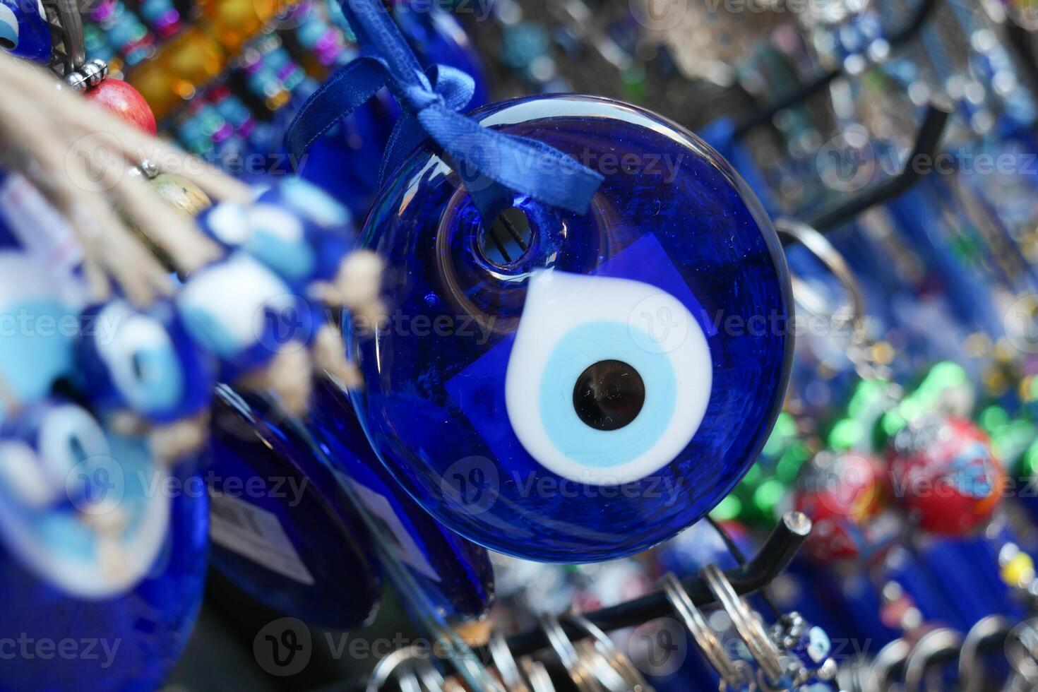 a bunch of blue evil eye keychains hanging on a shelf photo