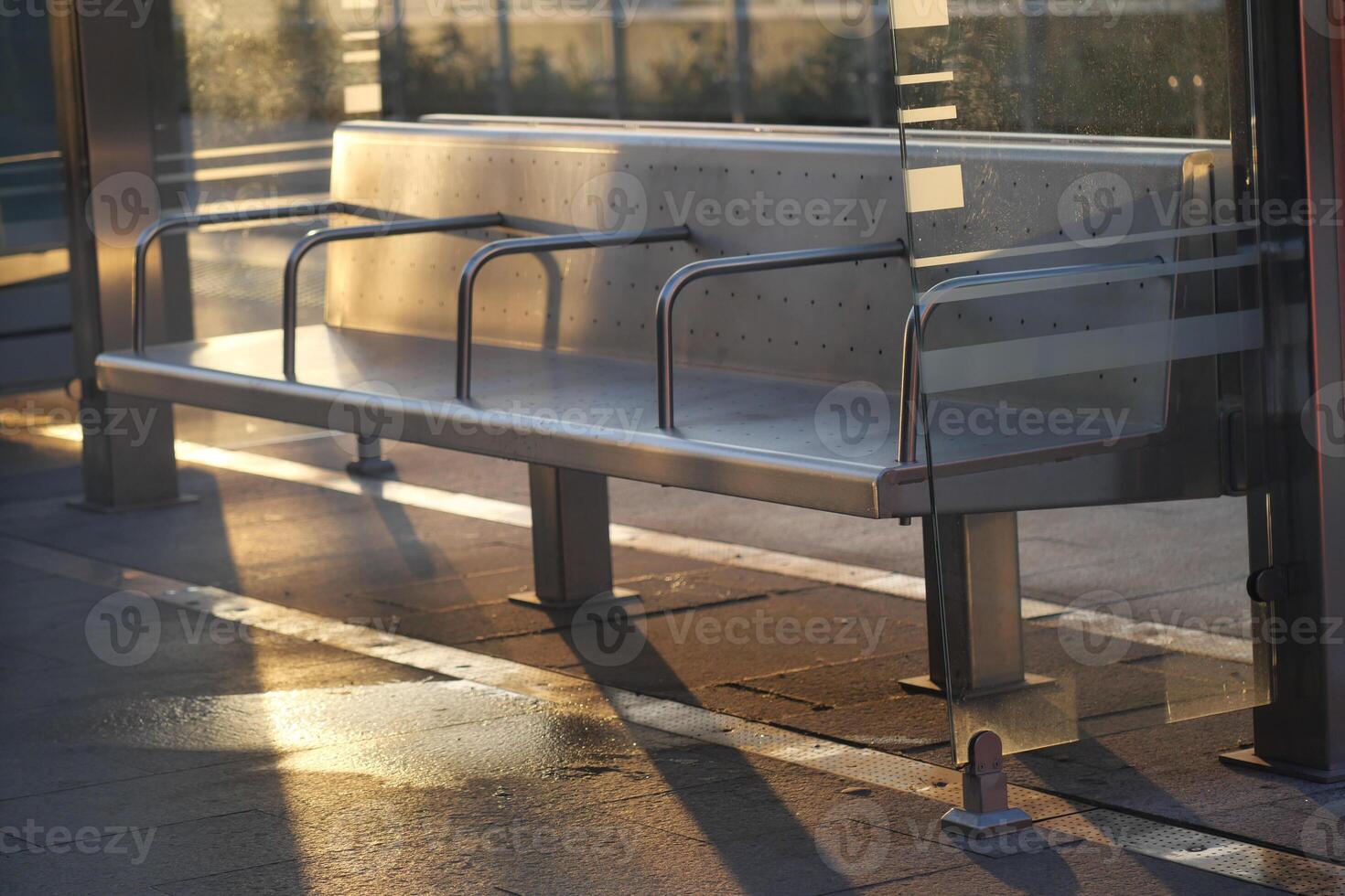 Modern Bus Stop Bench with Glass, beautifully reflecting sunlight photo