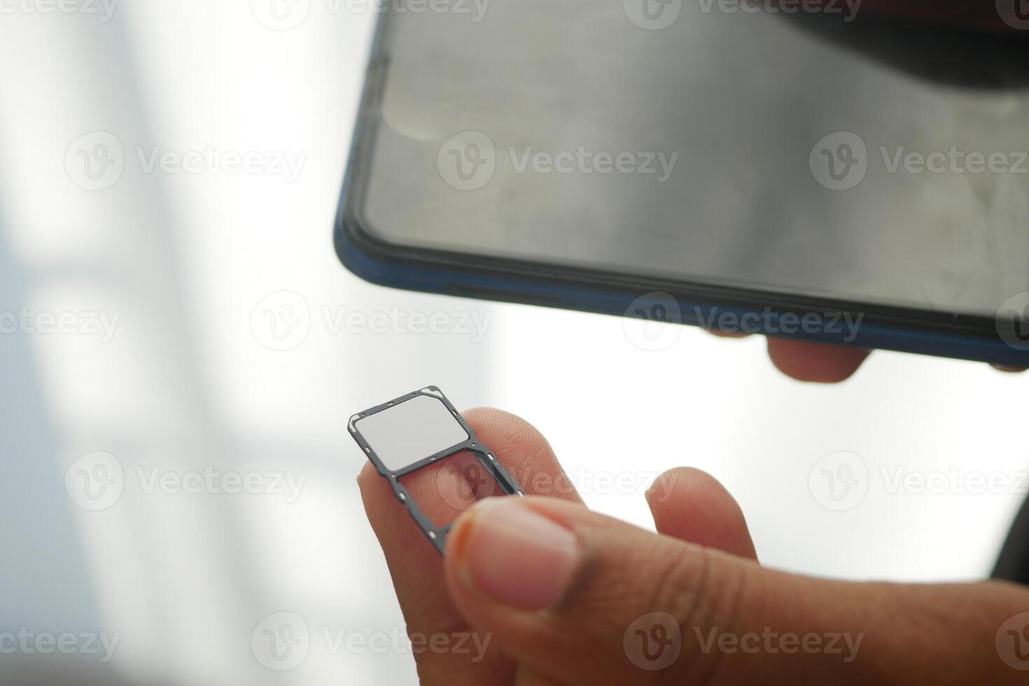 Inserting a SIM Card Into a Smartphone Device for Connectivity Setup photo