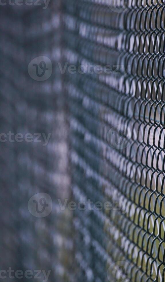 Abstract shot of a green wire mesh fence with defocusing effect. photo