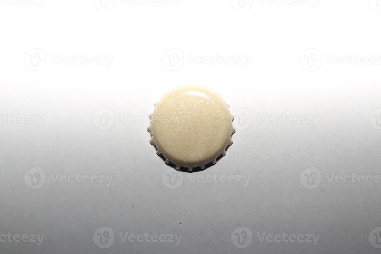A beige beer cap on lightness gradient. photo