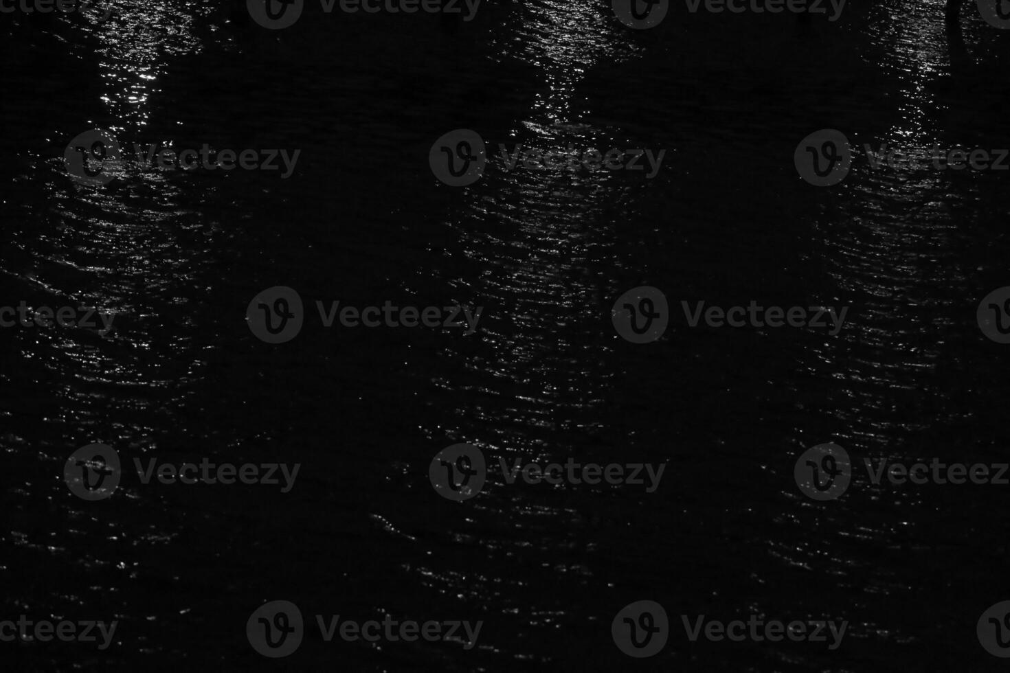 Reflections of whitelights on water in the night. photo